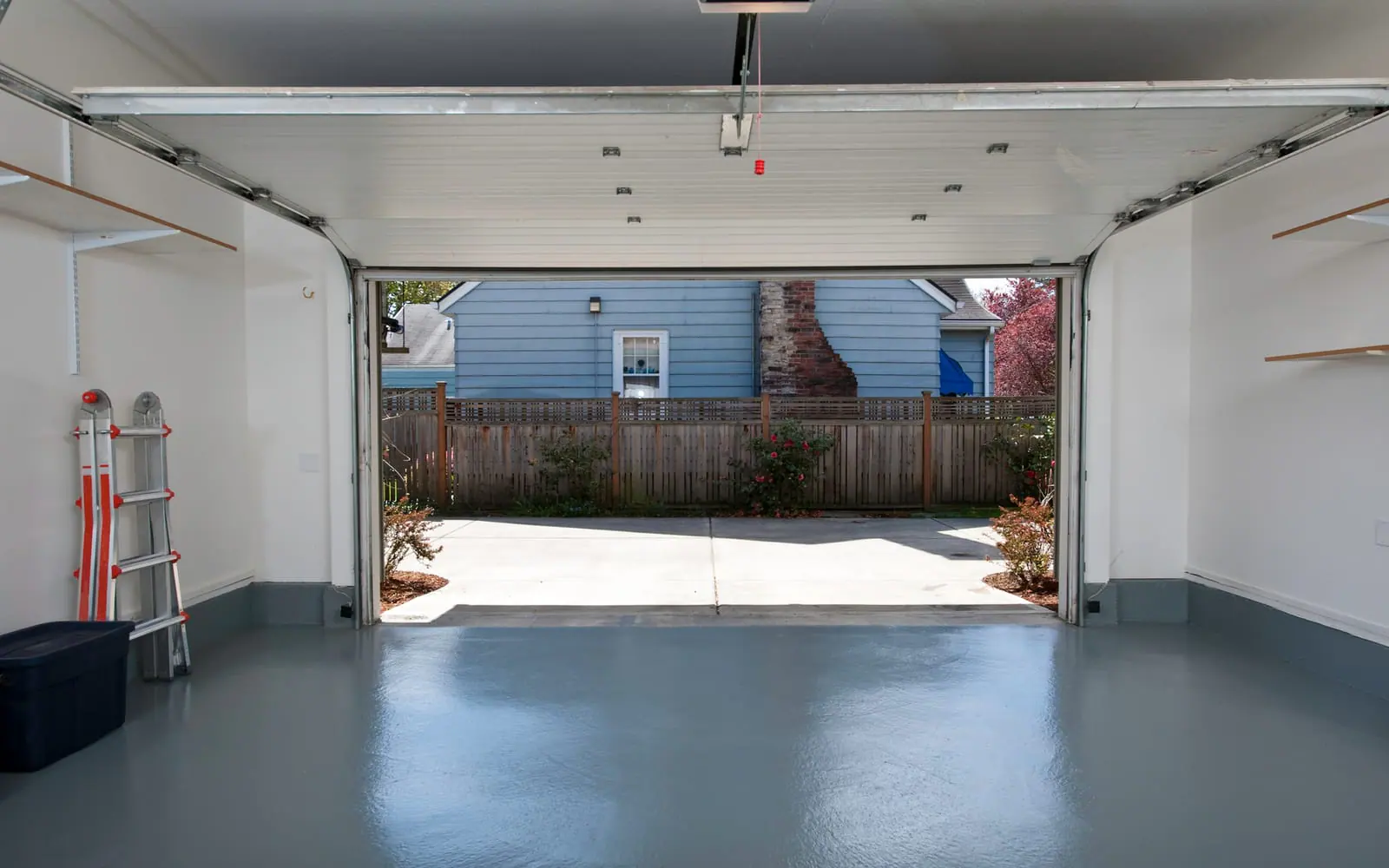 Open garage door seen from inside a clean garage, with the opener rail overhead