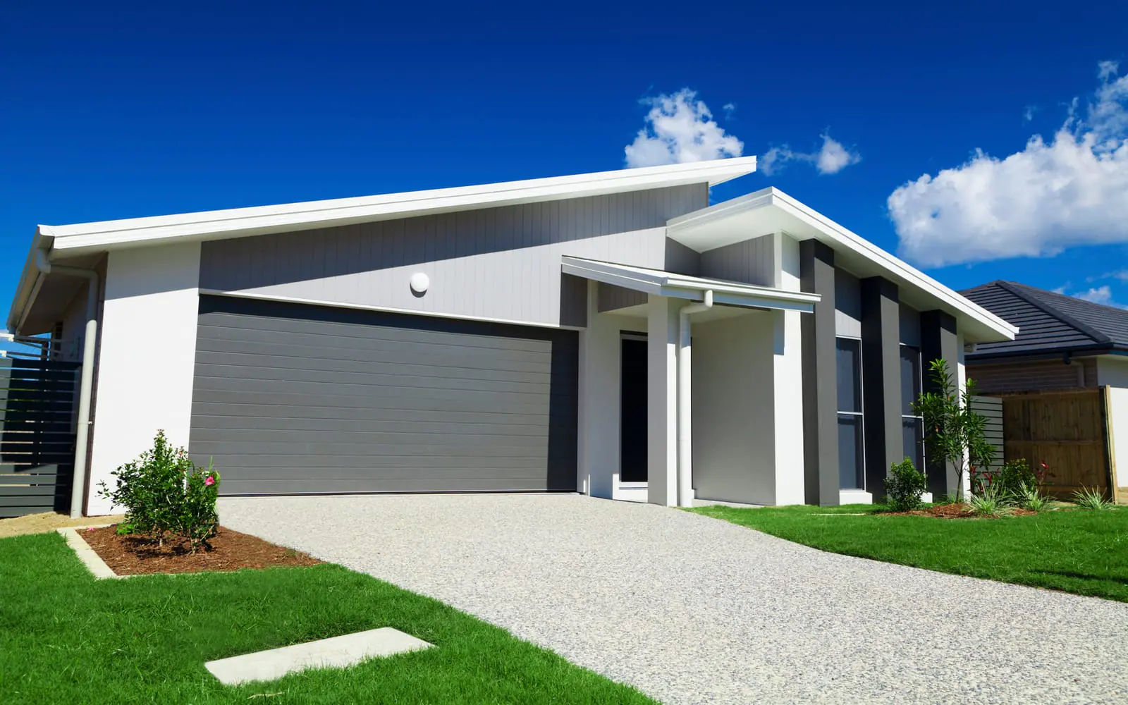 Modern home with a dark gray garage door beside the front entry