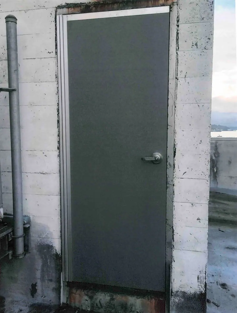 New gray steel door and frame in a concrete wall