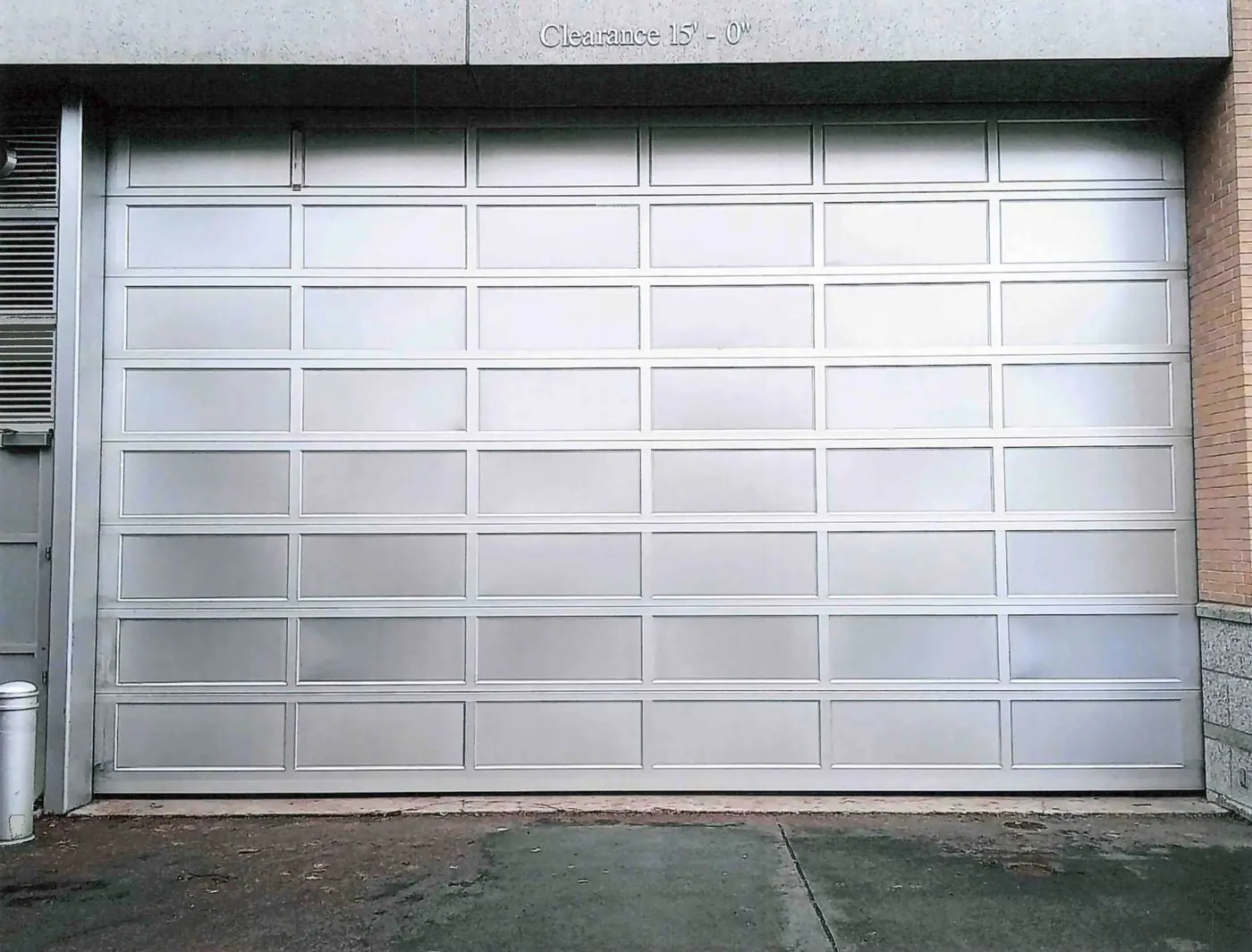 Full-view aluminum door with frosted glass at a garage entrance
