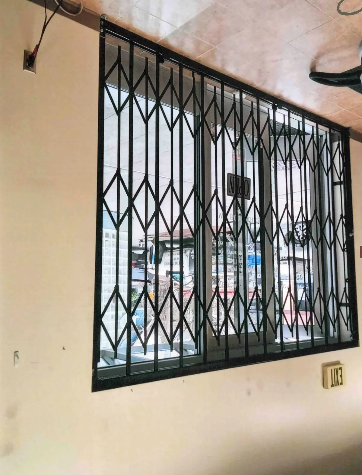 Folding gate over a storefront window, seen from inside