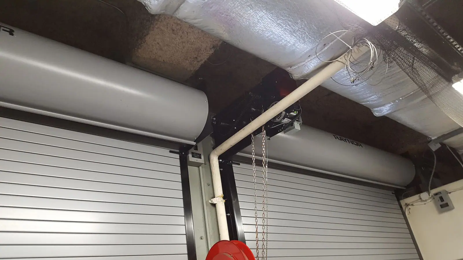 Raynor rolling door hoods with a chain hoist operator between them