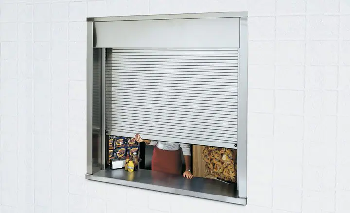 Raynor counter shutter part way open in a white wall