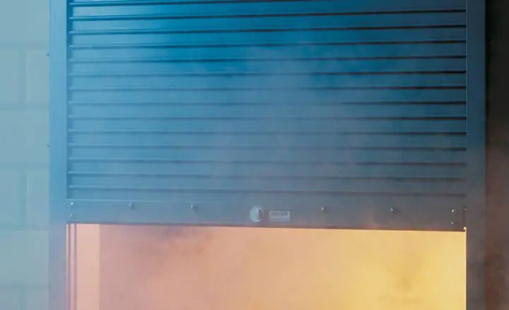 Raynor FireCurtain fire door curtain coming down in its guides, smoke behind it