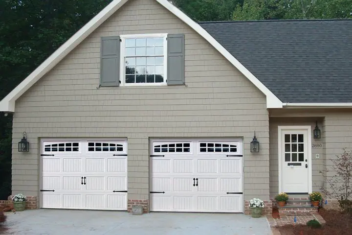 Home with two white carriage-style garage doors