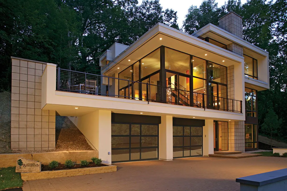 Modern home at dusk with full-view glass garage doors