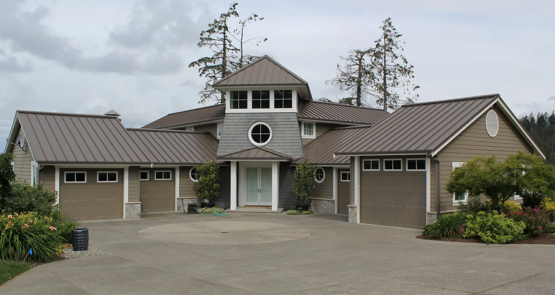 Home with three garage doors and a wide driveway