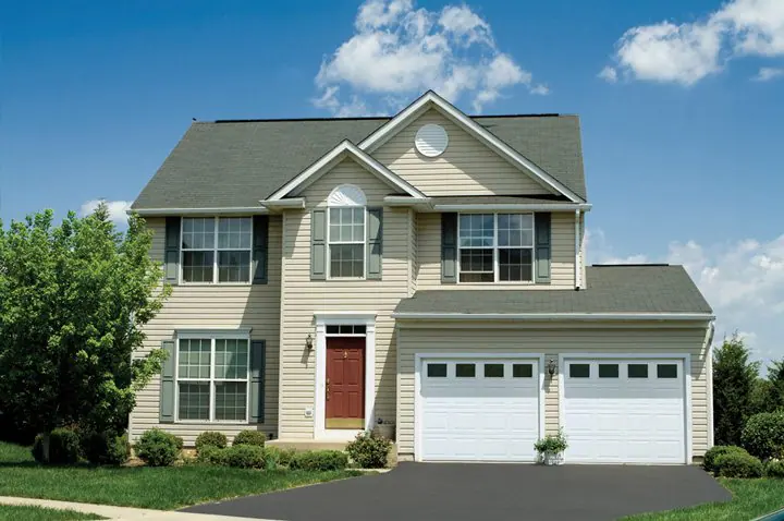 Two-story home with two white steel garage doors