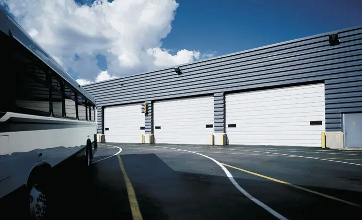 Row of white sectional doors on a steel building