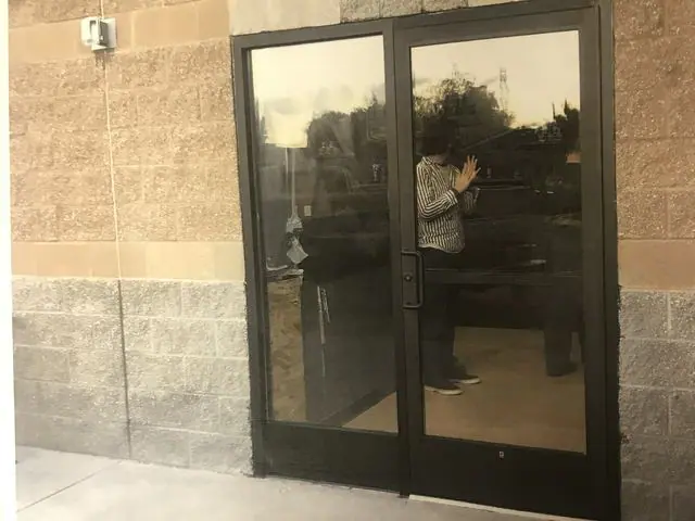 Pair of dark aluminum and glass storefront doors in a block wall